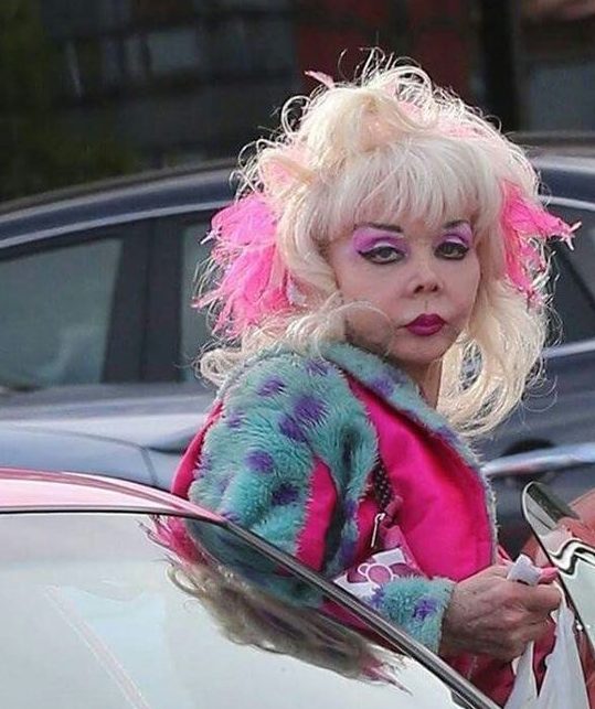 Angelyne, a bold cultural icon with vibrant pink and turquoise styling, reflecting the unapologetic ethos of Go Immaterial.